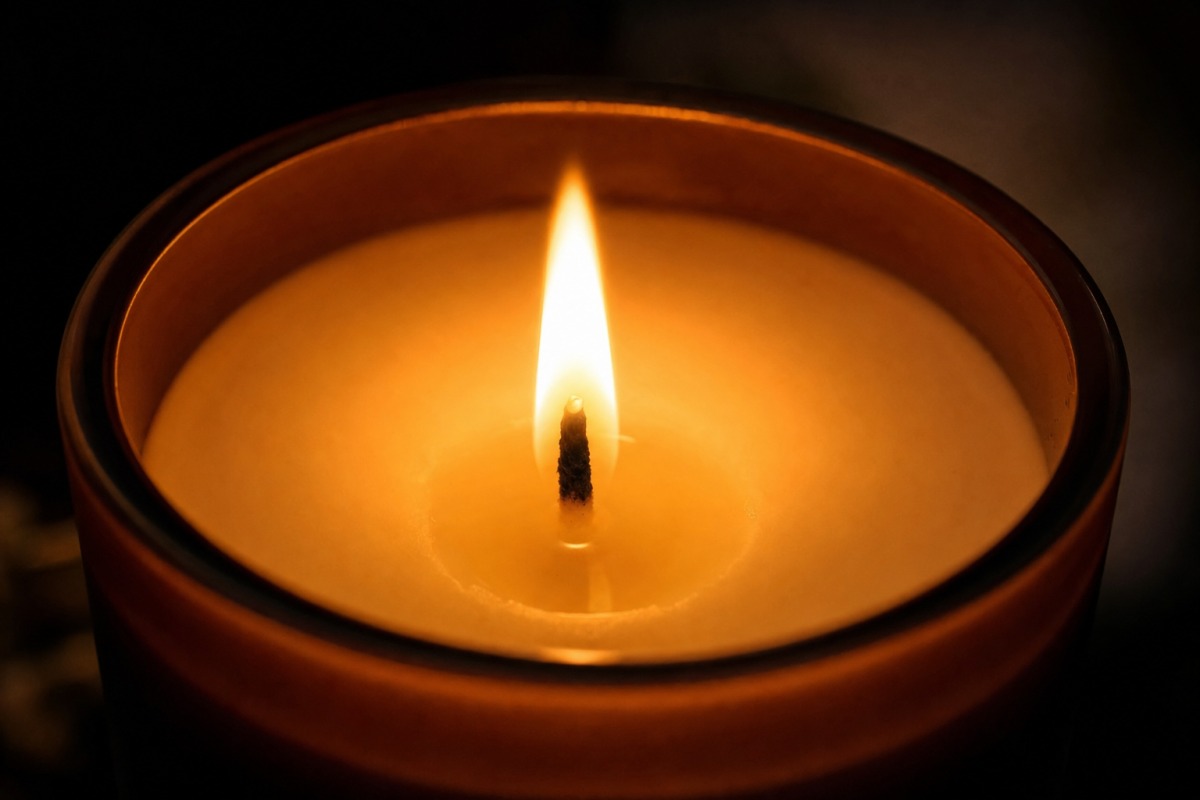 Gros plan sur la flamme régulière d'une bougie en cire végétale naturelle